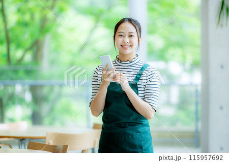 スマホを持つカフェの店員 115957692