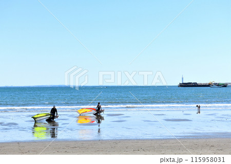 潮が引いた海岸から浜上がるウインドサーファー 潮が引いた海岸から浜上がるウインドサーファー 115958031
