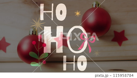 Two red Christmas ornaments hang in front of festive backdrop with HO HO HO text Two red Christmas ornaments hang in front of festive backdrop with HO HO HO text 115958784