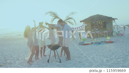 Group of friends enjoying a beach barbecue at sunset 115959669