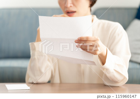 手紙を読んで泣く女性 115960147