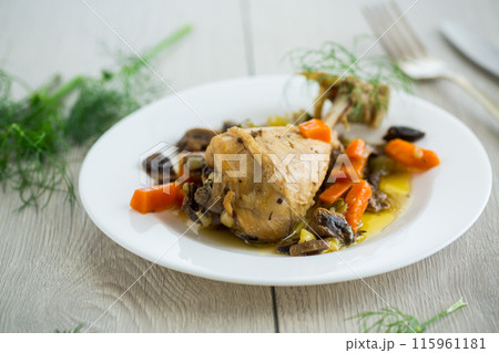 roast chicken with mushrooms and vegetables in a plate on a wooden table 115961181