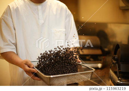 焙煎したコーヒー豆のチャフをふるい落とす様子 115963219