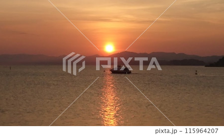 夕日と湖に浮かぶ船 115964207