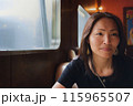 Asian woman in a diner talking 115965507