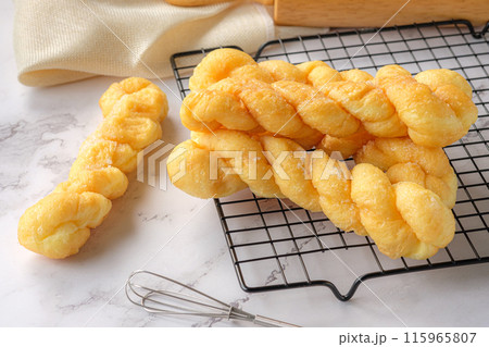 Glazed Twisted Donut on Cooling rack. 115965807
