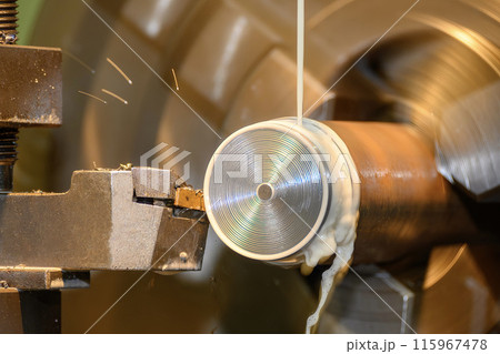 The lathe machine finish cut  metal shaft parts with liquid coolant method. 115967478