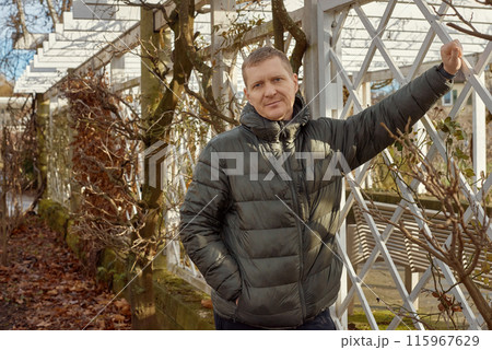 Portrait of handsome man standing outside in autumn weather. Calm Man Outdoors Relaxing And Breathing In Deeply In Autumn Park Portrait of handsome man standing outside in autumn weather. Calm Man Outdoors Relaxing And Breathing In Deeply In Autumn Park 115967629