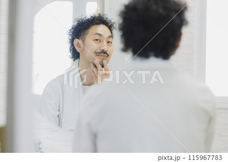 鏡を見ながら肌トラブルに悩む男性 115967783