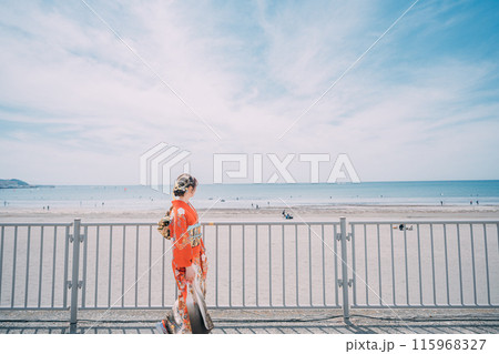 海岸を晴れ着で歩く新成人 115968327