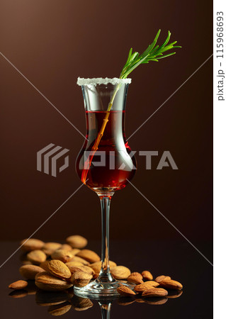 Italian liqueur Amaretto with almonds nuts on a brown background. Italian liqueur Amaretto with almonds nuts on a brown background. 115968693