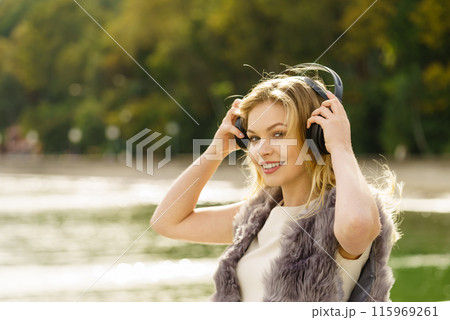 Happy woman wearing headphones outdoor Happy woman wearing headphones outdoor 115969261