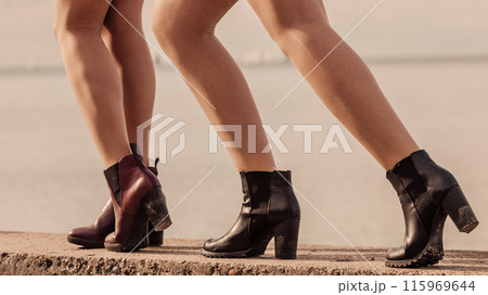 Three women presenting shoes outdoor 115969644