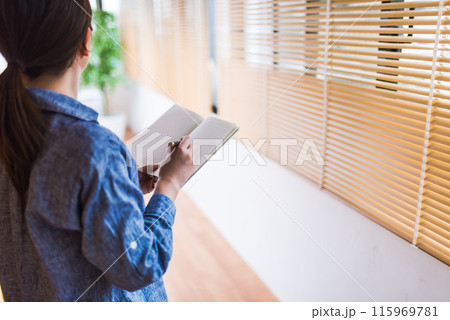 手帳を持つ女性 115969781