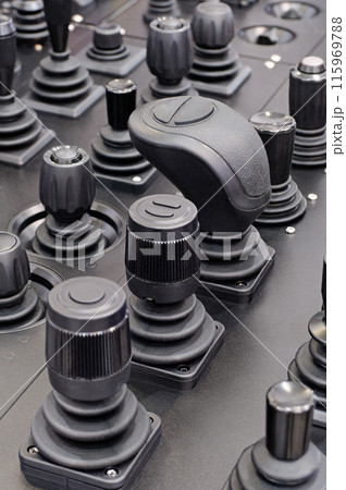 Various control sticks on a black dashboard 115969788