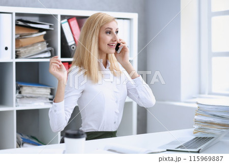Beautiful blonde smiling businesswoman talk cellphone 115969887