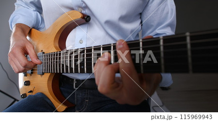 Male arms playing classic shape electric guitar 115969943