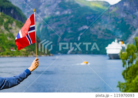Tourist with norwegian flag and ferry on fjord Tourist with norwegian flag and ferry on fjord 115970093