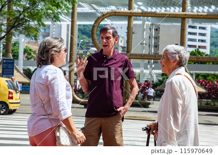 Senior tourists at the famous Jairo Varela Square. Senior travel concept. Senior people crossing the road using the crosswalk. Road safety. Pedestrian road safety Senior tourists at the famous Jairo Varela Square. Senior travel concept. Senior people crossing the road using the crosswalk. Road safety. Pedestrian road safety 115970649
