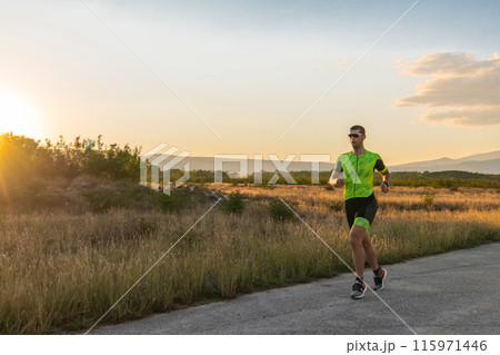 Triathlete in professional gear running early in the morning, preparing for a marathon, dedication to sport and readiness to take on the challenges of a marathon.  115971446