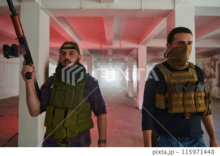An abandoned building serves as the stronghold for a team of terrorists, fiercely guarding their occupied territory with guns and military equipment An abandoned building serves as the stronghold for a team of terrorists, fiercely guarding their occupied territory with guns and military equipment 115971448