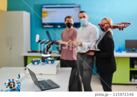 A group of students working together in a laboratory, dedicated to exploring the aerodynamic capabilities of a drone 115972148