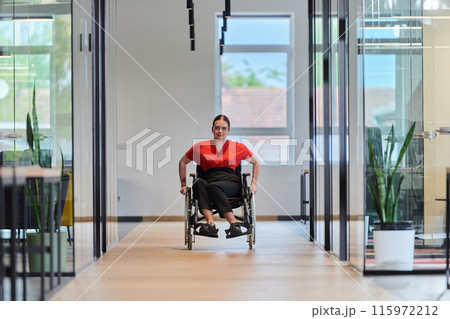 A modern young businesswoman in a wheelchair is surrounded by an inclusive workspace with glass-walled offices, embodying determination and innovation in the business world A modern young businesswoman in a wheelchair is surrounded by an inclusive workspace with glass-walled offices, embodying determination and innovation in the business world 115972212