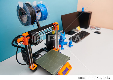 Modern 3d printer for creating 3d models and materials on the table in the laboratories next to the computer 115972213