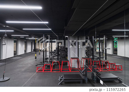 An empty modern gymnasium with a variety of equipment, offering a spacious, functional, and well-equipped training facility for workouts, fitness, and strength training An empty modern gymnasium with a variety of equipment, offering a spacious, functional, and well-equipped training facility for workouts, fitness, and strength training 115972265