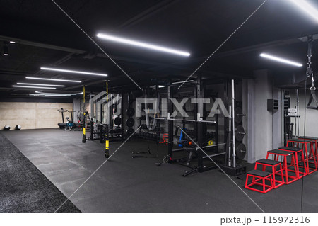 An empty modern gymnasium with a variety of equipment, offering a spacious, functional, and well-equipped training facility for workouts, fitness, and strength training An empty modern gymnasium with a variety of equipment, offering a spacious, functional, and well-equipped training facility for workouts, fitness, and strength training 115972316