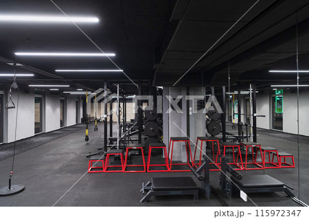 An empty modern gymnasium with a variety of equipment, offering a spacious, functional, and well-equipped training facility for workouts, fitness, and strength training An empty modern gymnasium with a variety of equipment, offering a spacious, functional, and well-equipped training facility for workouts, fitness, and strength training 115972347