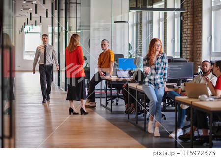 A diverse group of young business individuals congregates in a modern startup coworking center, embodying collaborative innovation and a dynamic atmosphere. 115972375