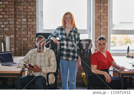 A diverse group of young business individuals congregates in a modern startup coworking center, embodying collaborative innovation and a dynamic atmosphere. A diverse group of young business individuals congregates in a modern startup coworking center, embodying collaborative innovation and a dynamic atmosphere. 115972432