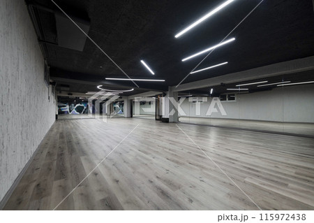 An empty dance hall with a glass wall adorned with decorative graffiti, offering a fusion of contemporary, urban artistic ambiance and impressive aesthetics. An empty dance hall with a glass wall adorned with decorative graffiti, offering a fusion of contemporary, urban artistic ambiance and impressive aesthetics. 115972438