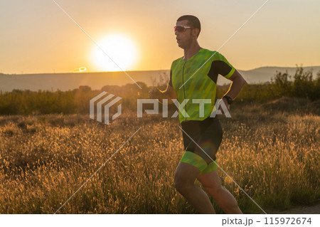 Triathlete in professional gear running early in the morning, preparing for a marathon, dedication to sport and readiness to take on the challenges of a marathon.  115972674