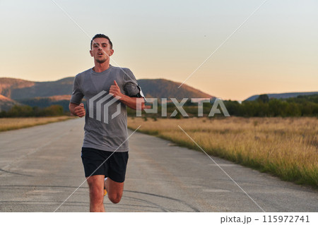 A young handsome man running in the early morning hours, driven by his commitment to health and fitness 115972741