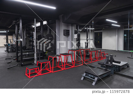 An empty modern gymnasium with a variety of equipment, offering a spacious, functional, and well-equipped training facility for workouts, fitness, and strength training An empty modern gymnasium with a variety of equipment, offering a spacious, functional, and well-equipped training facility for workouts, fitness, and strength training 115972878