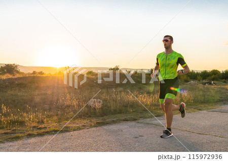 Triathlete in professional gear running early in the morning, preparing for a marathon, dedication to sport and readiness to take on the challenges of a marathon.  115972936