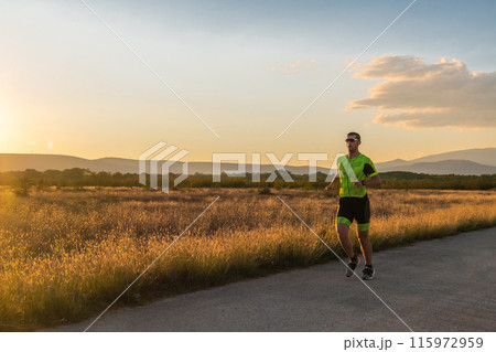 Triathlete in professional gear running early in the morning, preparing for a marathon, dedication to sport and readiness to take on the challenges of a marathon.  115972959