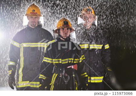 A group of professional firefighters marching through the rainy night on a rescue mission, their determined strides and fearless expressions reflecting their unwavering bravery and unwavering A group of professional firefighters marching through the rainy night on a rescue mission, their determined strides and fearless expressions reflecting their unwavering bravery and unwavering 115973066