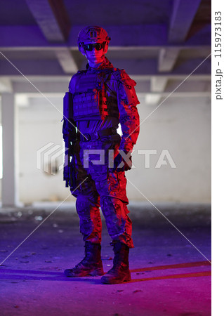 A professional soldier undertakes a perilous mission in an abandoned building illuminated by neon blue and purple lights A professional soldier undertakes a perilous mission in an abandoned building illuminated by neon blue and purple lights 115973183