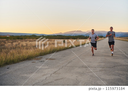 Group of handsome men running together in the early morning glow of the sunrise, embodying the essence of fitness, vitality, and the invigorating joy of embracing nature's tranquility during their Group of handsome men running together in the early morning glow of the sunrise, embodying the essence of fitness, vitality, and the invigorating joy of embracing nature's tranquility during their 115973184