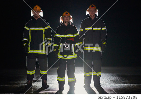 A group of professional firefighters marching through night on a rescue mission, their determined strides and fearless expressions reflecting their unwavering bravery and unwavering commitment to 115973208
