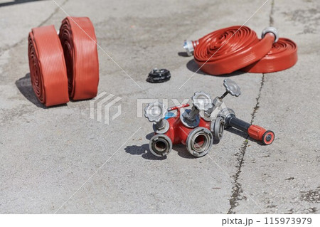 Coiled Fire Hose Ready for Action on the Ground 115973979