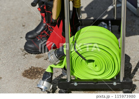 Coiled Fire Hose Ready for Action on the Ground 115973980