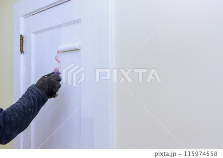 Doors are painted with white paint with roller during repairs Doors are painted with white paint with roller during repairs 115974558