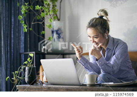 mature asian woman working from home video chatting using laptop computer mature asian woman working from home video chatting using laptop computer 115974569