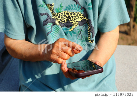 スマホを操作するおふくろの手元 115975025