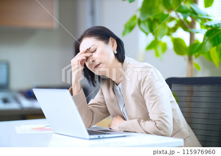 オフィスで疲れを見せるミドル女性 115976960