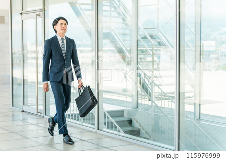 会社・オフィスに出勤・出社訪問営業・新規開拓・飛び込み営業に来た通勤する若い男性アジア人ビジネスマン 115976999